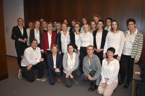 Gruppenfoto von Personen in hellen Outfits.