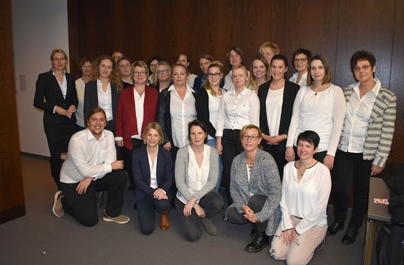 Gruppenfoto von Personen in hellen Outfits.